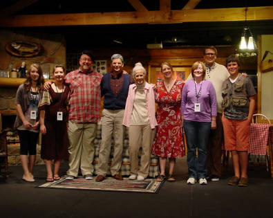 9 people standing together in a theater